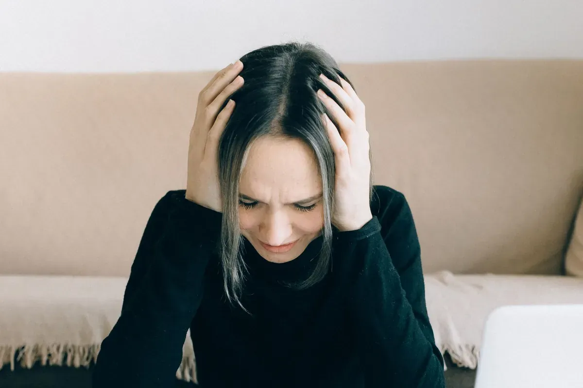 A person sitting with their head in their hands