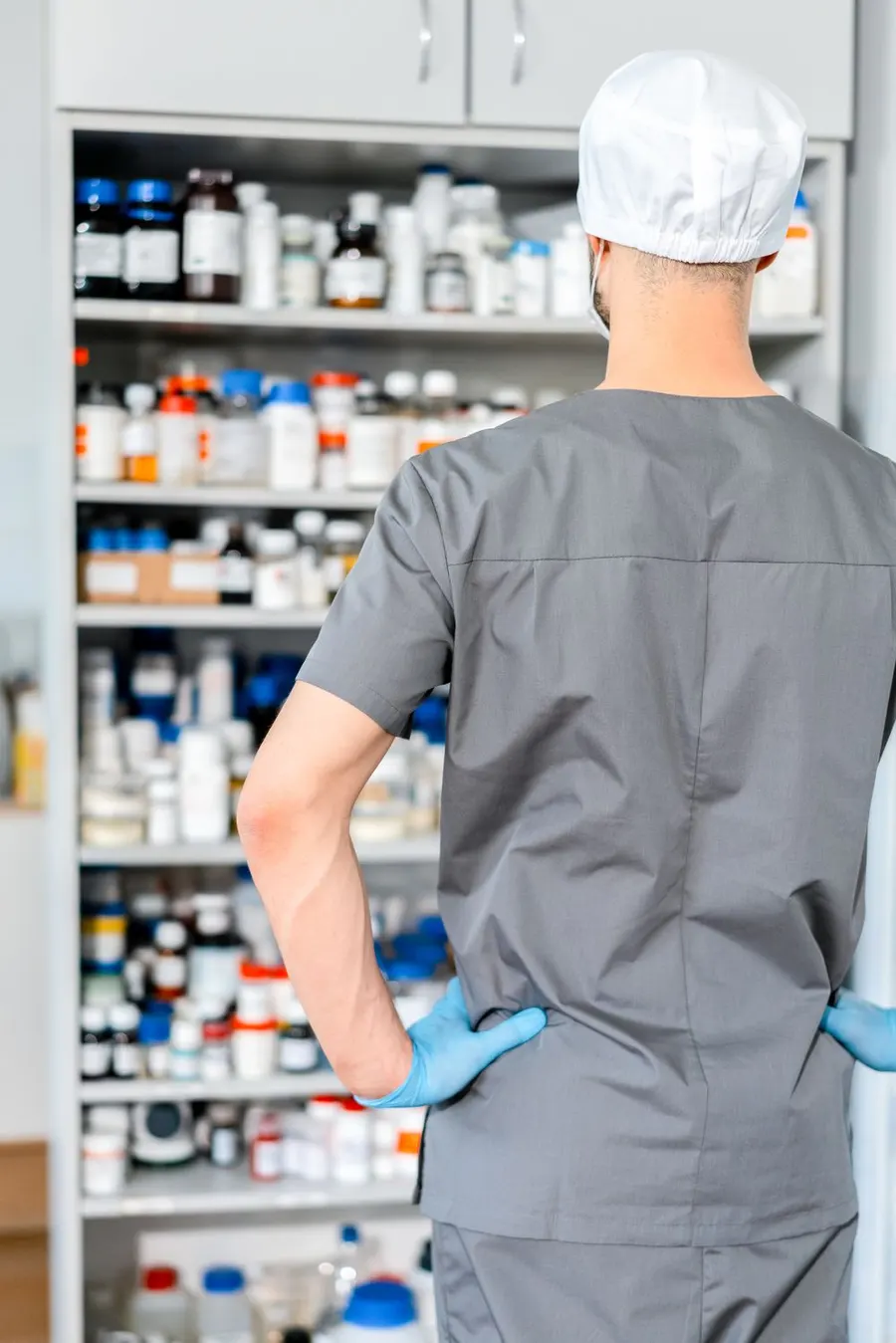 A pharmacist preparing medication near the shelves