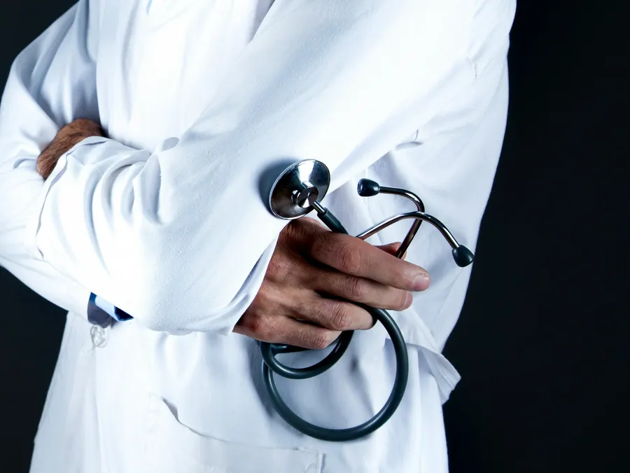 A white coat and stethoscope in a clinical setting