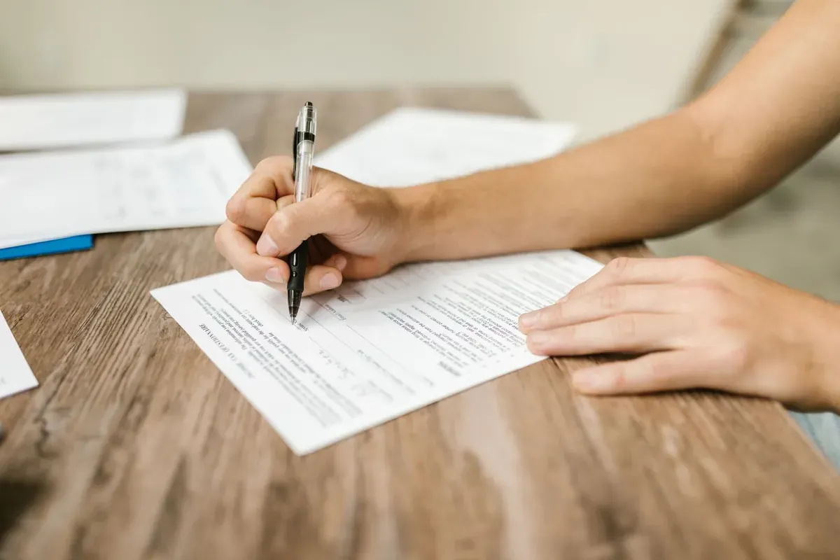 A person filling out a form at a desk