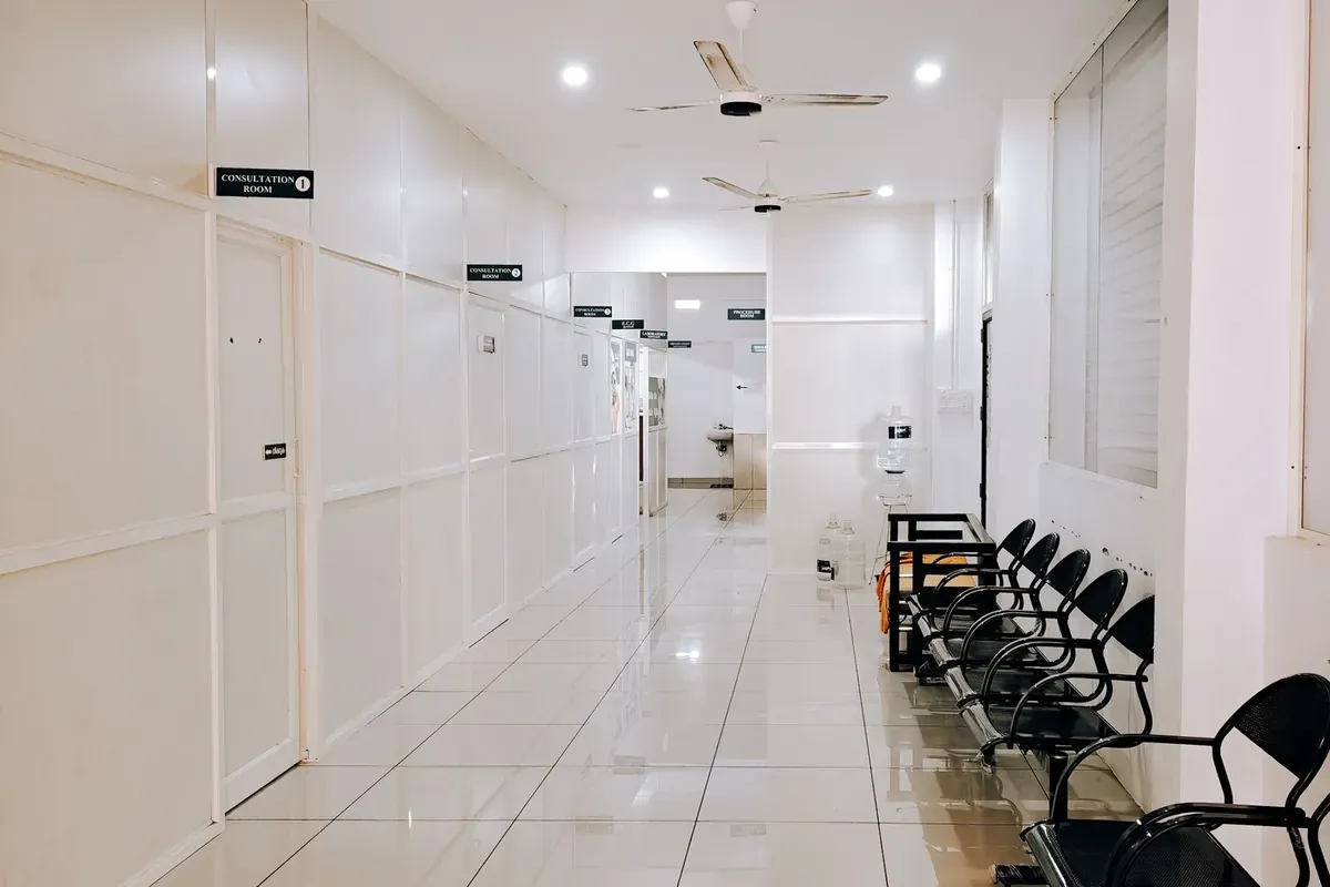 An empty hospital corridor lined with waiting chairs