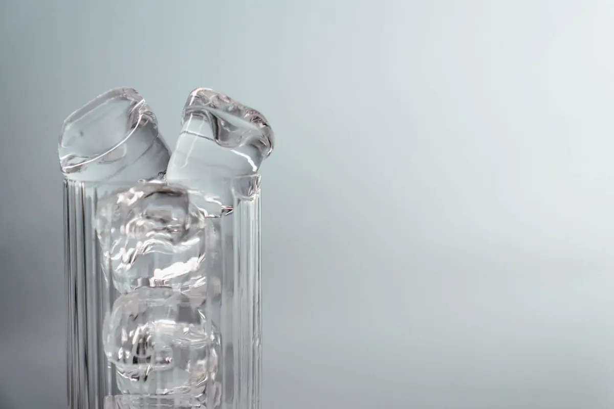 Glass water bottles on a pale background